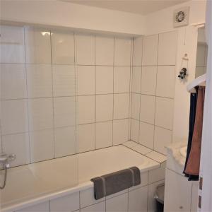 a white tiled bathroom with a tub and a sink at The View Fellering in Fellering +11 photos