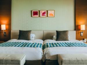 two beds sitting next to each other in a hotel room at Miyakojima Tokyu Hotel & Resorts in Miyako-jima