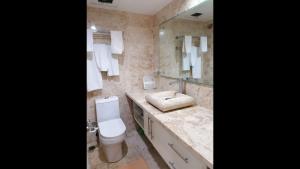 a bathroom with a toilet and a sink and a mirror at Apartment Monocal in Boca Chica in Boca Chica