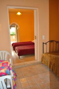 a bedroom with two beds and a mirror at Beachfront holiday Houses Yannis on Agios Gordios beach in Agios Gordios +20 photos