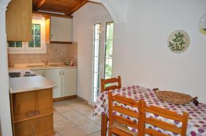 a kitchen with a table and a kitchen with a table and a kitchen at Corfu Beachfront holiday Houses Yannis on Agios Gordios beach in Agios Gordios