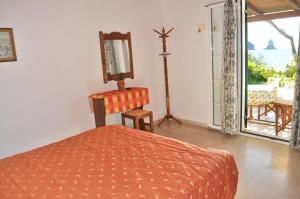 a bedroom with a bed and a window with a view at Corfu Beachfront holiday Houses Yannis on Agios Gordios beach in Agios Gordios