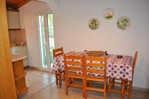 a dining room with a table and chairs and a kitchen at Corfu Beachfront holiday Houses Yannis on Agios Gordios beach in Agios Gordios