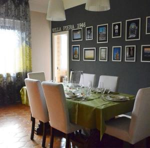 a dining room table with a green table cloth and white chairs at Room in Apartment - Villa Piera holiday home in Cremona apartment with independent entrance in Cremona