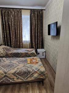 a bedroom with a bed and a flat screen tv at Harmony in Cherepovets