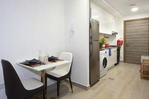 a kitchen with a table and chairs and a refrigerator at Signature Holiday Homes - Stunning Furnished Studio Apartment in JVC in Dubai