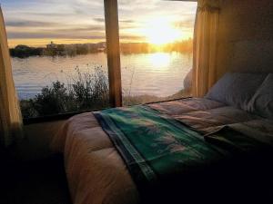a bedroom with a window with a view of a lake at Lucsay Titicaca Lodge in Puno
