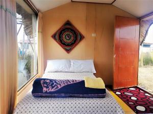 un lit à l'arrière d'une petite maison dans l'établissement Room in Lodge - Lucsay Titicaca Lodge, à Puno