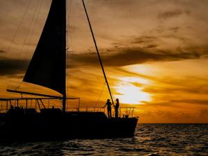 two people standing on a sailboat at sunset at Miyakojima Tokyu Hotel & Resorts in Miyako-jima