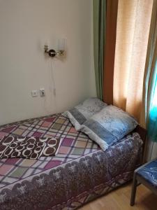 a small bedroom with a bed and a window at Harmony in Cherepovets