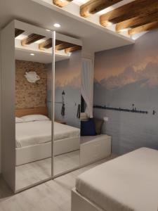 a bedroom with two beds and a mirror at Stravedamento MyTravelChioggia in Chioggia