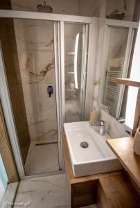 a bathroom with a sink and a shower at PIHE apartmanok in Balatonfüred