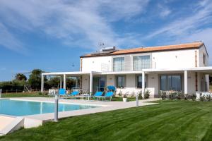 a villa with a swimming pool and a yard at Case Playa Resort Balestrate in Balestrate