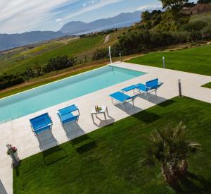 una vista aérea de una piscina con sillas y una mesa en Case Playa Resort Balestrate, en Balestrate