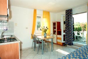 a kitchen with a table and chairs in a kitchen at Appartamenti Doria II in Porto Garibaldi