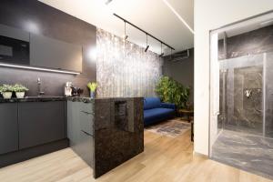 a bathroom with a shower and a blue couch at Jacuzzi Apartment Main Square in Krakow