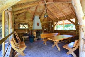 - une table et des chaises en bois dans une cabine avec cuisinière dans l'établissement Leśny Zakątek balia kąpielowa ognisko sauna basen rowery w cenie pobytu, à Kruszyniany