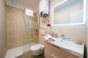 uma casa de banho com um lavatório, um chuveiro e um WC. em Amaris luxury apartments em Split