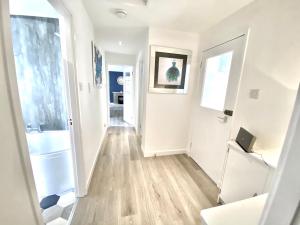 a hallway of a home with white walls and wood floors at Stylish Central 2 Bedroom Apartment - Free Parking, Free WiFi in Orkney