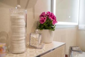 a bathroom counter with a vase with flowers and a candle at Amaris luxury apartments in Split