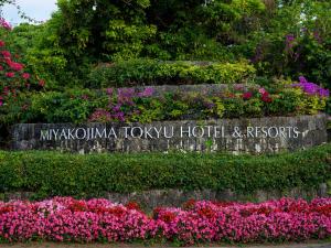 a sign for myoko tox toxu hotel and resorts with flowers at Miyakojima Tokyu Hotel & Resorts in Miyako-jima