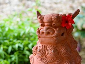 a clay statue of a pig with a red flower on it at Miyakojima Tokyu Hotel & Resorts in Miyako-jima