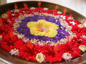 a flower arrangement of red and purple flowers in a bowl at Miyakojima Tokyu Hotel & Resorts in Miyako-jima