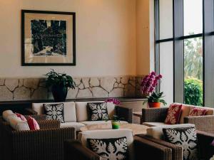 a living room with couches and a table and chairs at Miyakojima Tokyu Hotel & Resorts in Miyako-jima