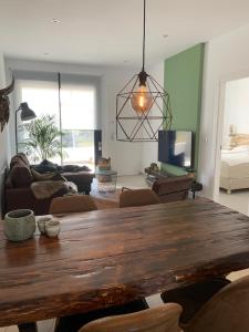 a living room with a wooden table and a couch at Penthouse Las 2 Salchichas in San Javier