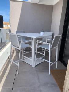 a white table and chairs on a balcony at Penthouse Las 2 Salchichas in San Javier