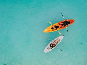 an orange boat and a white kayak in the water at Miyakojima Tokyu Hotel & Resorts in Miyako-jima