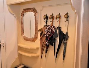 un estante de sombrillas colgando en una pared con un espejo en Ferienwohnung Koppi, en Pamhagen