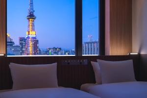 
a hotel room with a large window overlooking a city at Bespoke Hotel Sapporo in Sapporo
