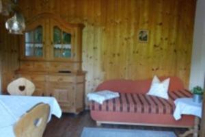 a bedroom with a red couch and wooden walls at Ferienwohnung Zugspitze in Grainau