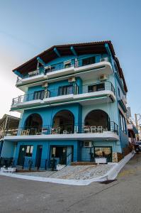 ein blaues Gebäude mit Balkon auf der Seite in der Unterkunft Soulis Hotel in Arkoudi