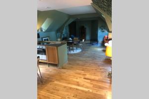 a kitchen and living room with a wooden floor at L’annexe du Manoir in Gauciel