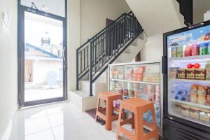 una tienda de comestibles con dos taburetes y una nevera en RedDoorz near Arka Sepinggan Airport en Balikpapan