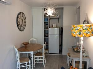 eine Küche und ein Esszimmer mit einem Tisch und einer Uhr an der Wand in der Unterkunft Le Cottage des Mésanges in Villefranche-de-Rouergue