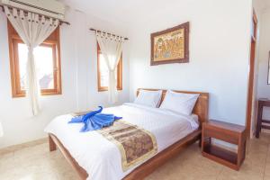 Un dormitorio con una cama con una toalla azul. en Teba House Ubud by ecommerceloka - CHSE Certified, en Ubud