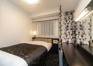 um quarto de hotel com uma cama e uma janela em APA Hotel Namba-Shinsaibashi Nishi em Osaka