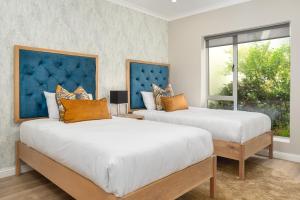 1 dormitorio con 2 camas y ventana en Dolphin Beach E30 en Ciudad del Cabo