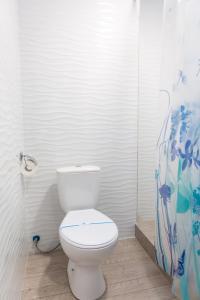 a bathroom with a white toilet in a room at Zenith Hotel in Odesa