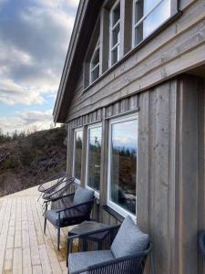 un groupe de chaises assises sur le côté d'un bâtiment dans l'établissement Ski in-out at Lifjell-Mountain cabin with majestic views close to Bø Sommarand, à Bø