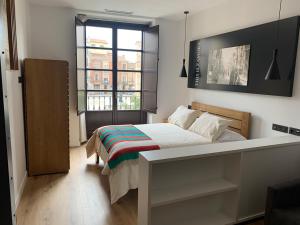 a bedroom with a bed and a large window at Apartamentos Plaza Mayor Zamora in Zamora