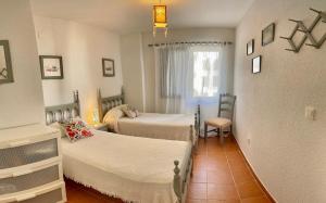 a bedroom with two beds and a window at Zahara almadraba playa Atlanterra in Zahara de los Atunes +22 photos