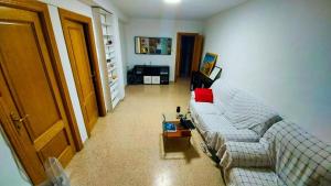 sala de estar con sofá blanco y almohada roja en Room in an apartment en Granada