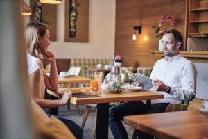 a man and woman sitting at a table in a restaurant at der klostertalerhof in Klösterle