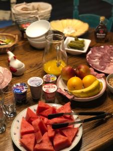 uma mesa de madeira coberta com pratos de melancia e fruta em Chata pod Obřím hradem em Nuzau