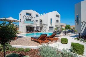 a villa with a swimming pool and two chairs at The Victoria Lefkada in Lefkada Town