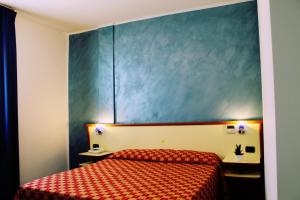 a bedroom with a bed and a blue wall at Hotel Miravalle in Ribera